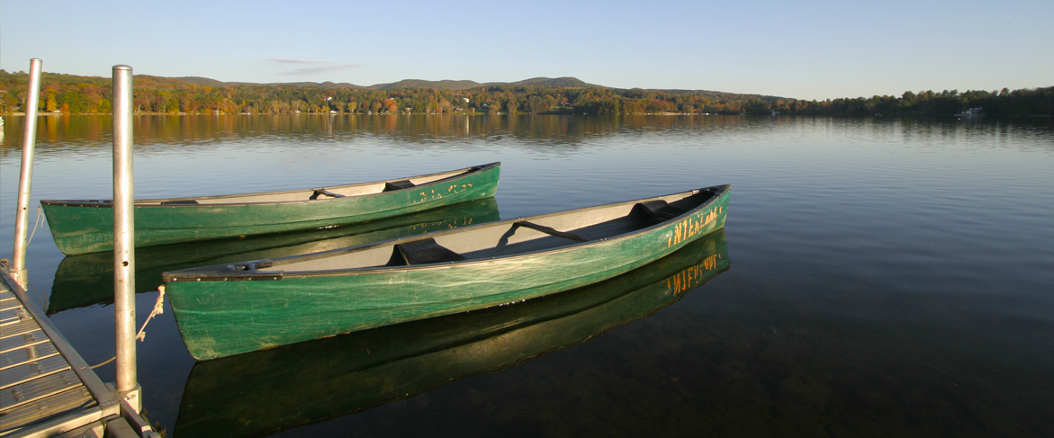 two canoes tied up at the edge of a large lake